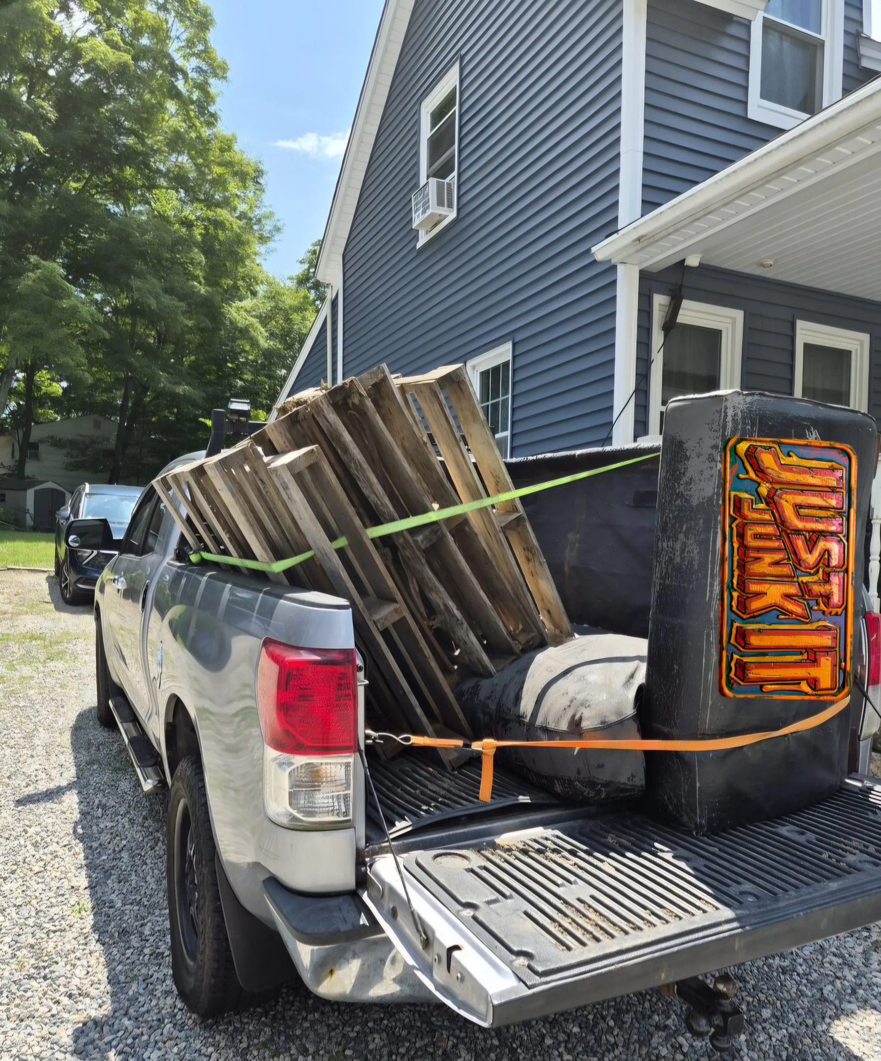 Truck bed loaded with pallets and a mattress on a Just Junk It job